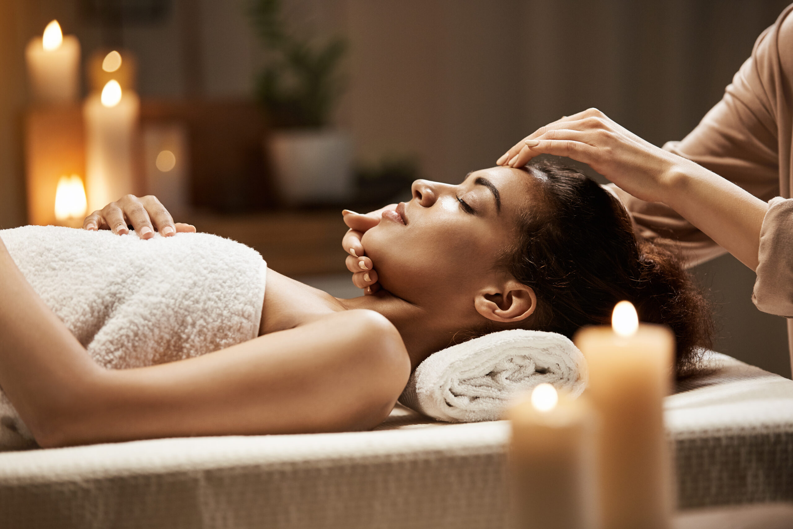 attractive african woman enjoying face massage spa salon scaled